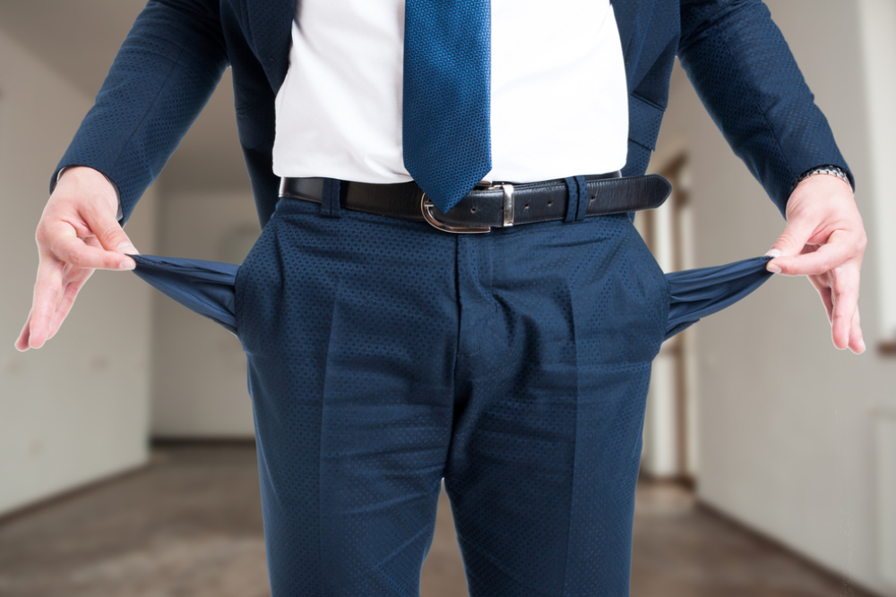 closeup of male realtor showing his empty suit pockets as bankruptcy