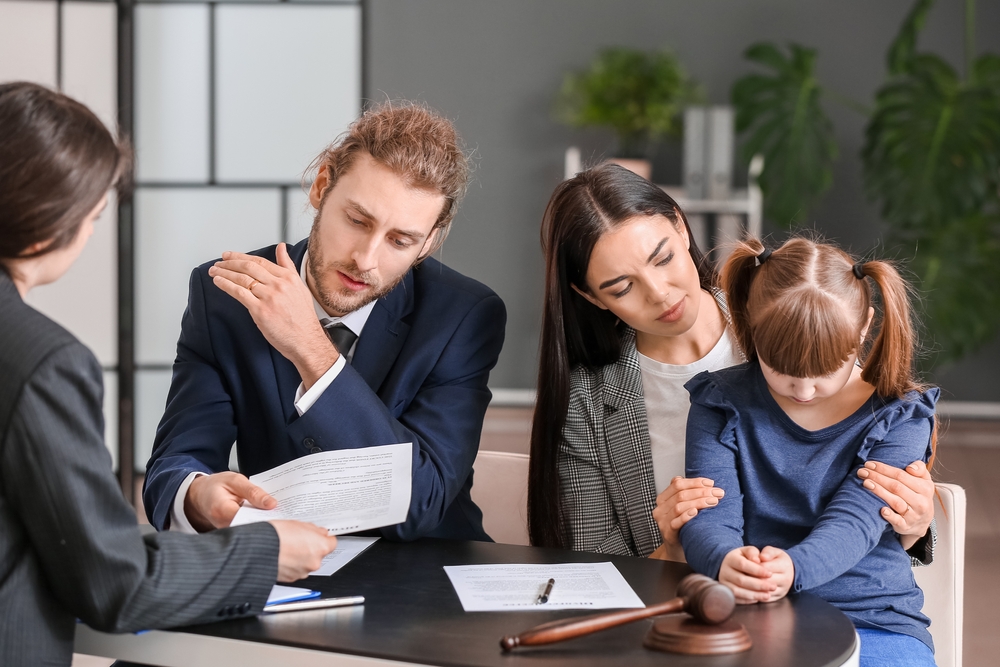 Young couple and their daughter visiting divorce lawyer in office