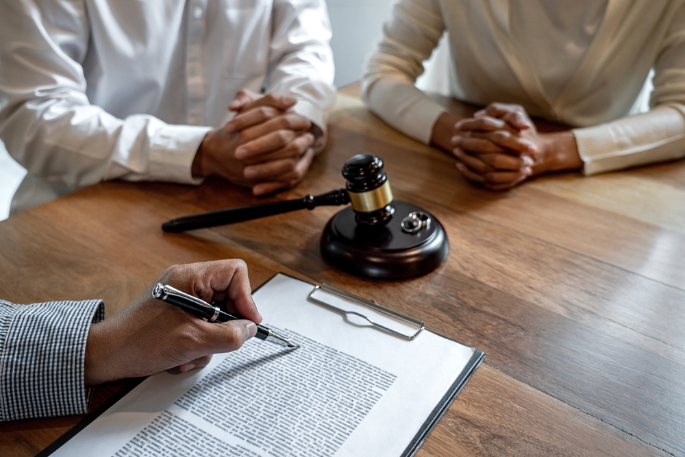 divorce couple having conflict, husband and wife during divorce process with senior male lawyer or counselor and couple signing decree of divorce contract in lawyer's office