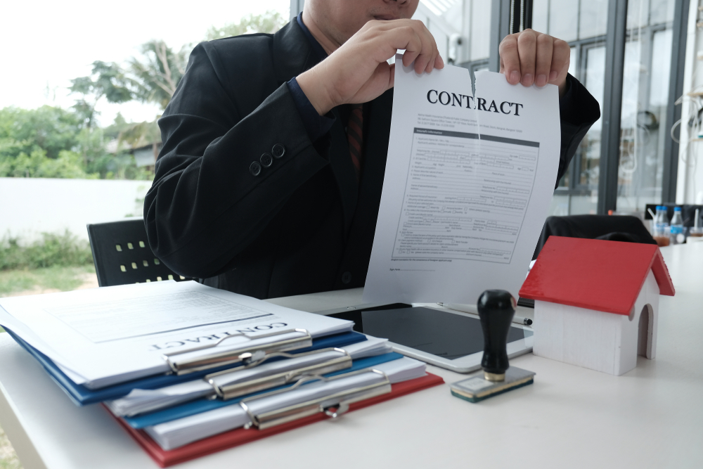 businessman tearing agreement document. breaking contract at office